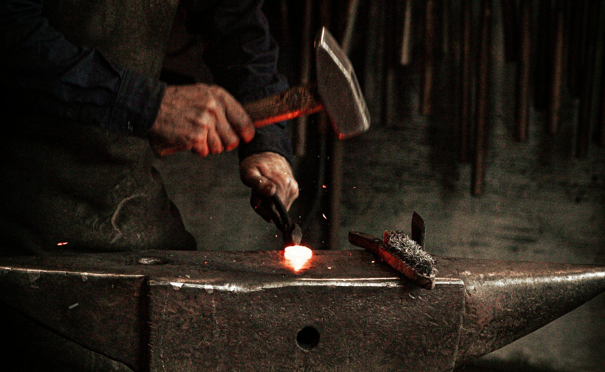 a man working on a piece of metal with a hammer